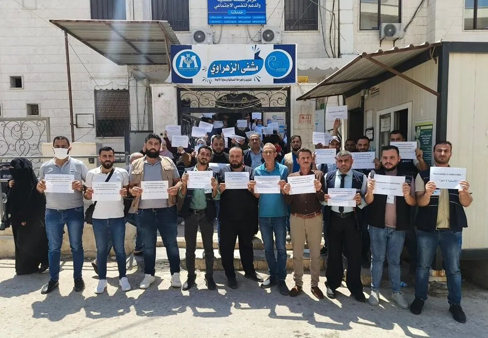 إدلب: احتجاجات ضد وفد IMC بقيادة وفاء صادق بسبب اتهامات بفرض موالين للنظام وتهديد بوقف الدعم