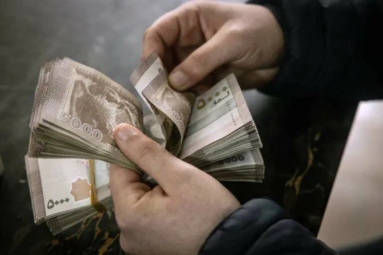أزمة السيولة الخانقة في سوريا: قيود السحب المصرفي تفاقم معاناة المواطنين وتنعش السوق السوداء