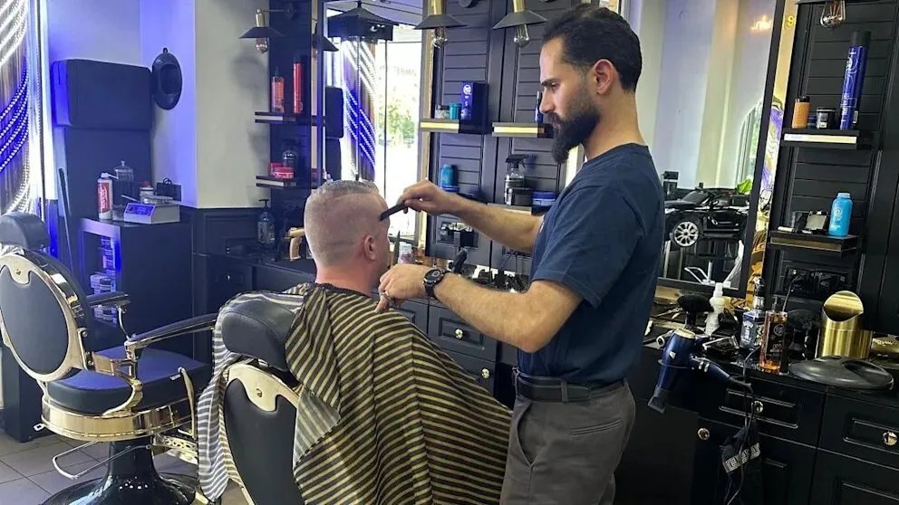 من حلب إلى براندنبورغ: قصة نجاح لاجئ سوري يتحول إلى صاحب صالون حلاقة